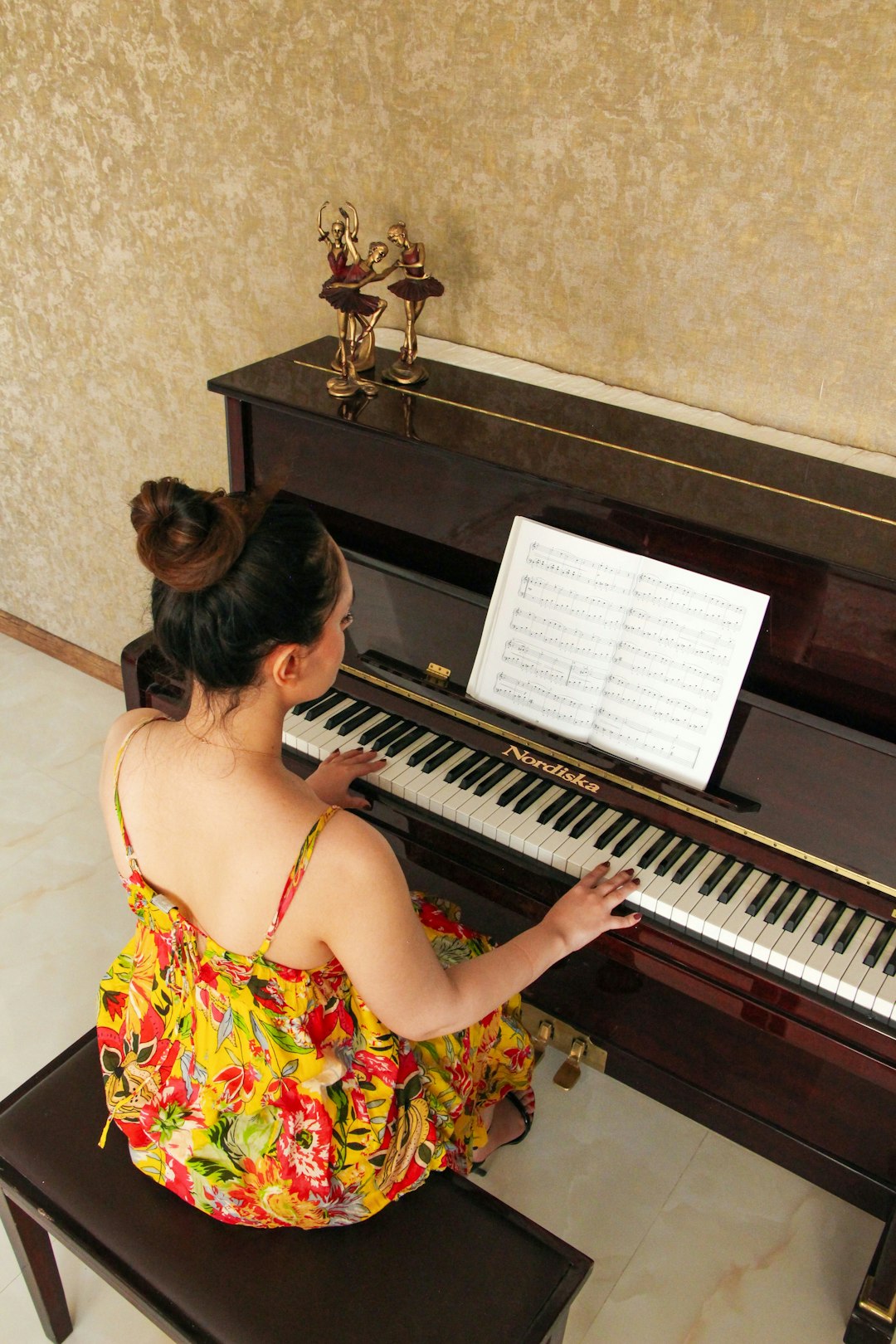 our-journey-02 a-woman-sitting-on-a-bench-playing-a-piano-9vlt2qnf1uc