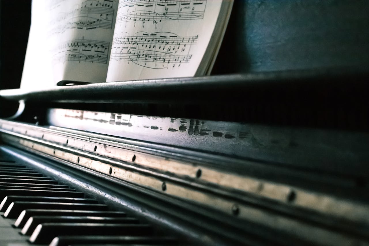 services-03 Close-up of piano keys with an open sheet music, creating a classic musical ambiance.